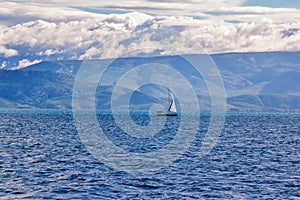 Beautiful seascape with yacht, mountains on background