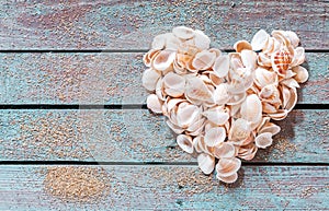 Beautiful seashell heart on rustic wood photo