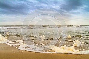 Beautiful seaside landscape - view of the shore of the North Sea with the breaking wave