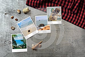 Beautiful seaside snapshots arranged on rustic wooden background with seashells around