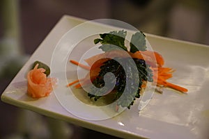 beautiful seaweed on top of piece of sashimi at japanese restaurant at night