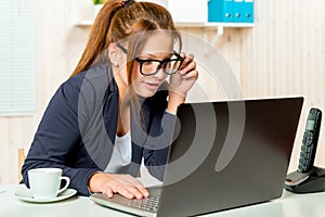 Beautiful secretary carefully scans email on the computer