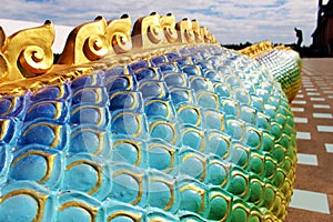 Beautiful Rainbow colors of Praya Nark or Naga in Thai temple with colorful sky and sun flare effect on sunrise time