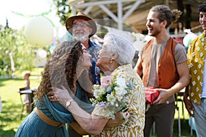 Beautiful senior birthday woman hugging her granddaughter.