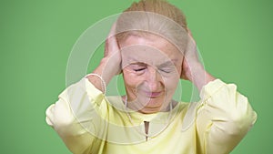 Beautiful senior businesswoman covering ears as three wise monkeys concept