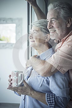 Beautiful senior caucasian couple at home enjoyig love and relationship - concept of coronavirus quarantine stayhome lockdown