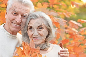 Beautiful senior couple in autumn park with leaves