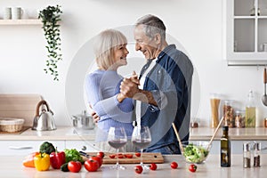 Beautiful senior couple celebrating anniversary, making dinner