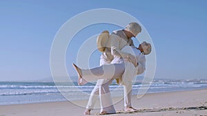 Beautiful senior couple dancing at seashore, spending time.