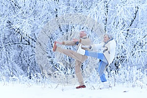 Senior couple doing exercises in winter forest