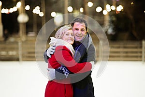 Beautiful senior couple ice skating in city centre. Winter