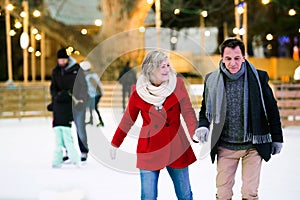 Beautiful senior couple ice skating in city centre. Winter