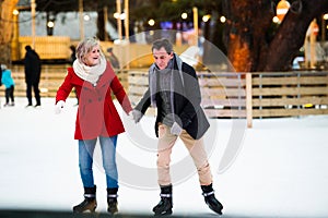 Beautiful senior couple ice skating in city centre. Winter