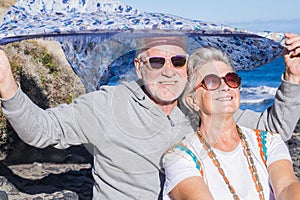 Beautiful senior couple models enjoying the sunlight on the faces during the vacation