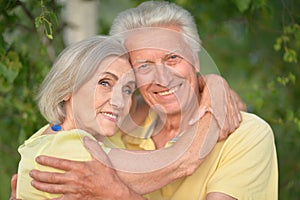 Beautiful senior couple posing and hugging in the park