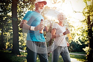 Beautiful senior couple running outside in forest