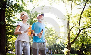 Beautiful senior couple running outside in forest