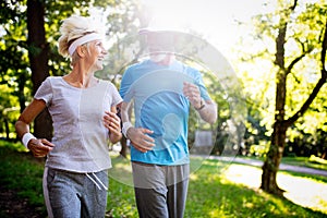 Beautiful senior couple running outside in forest