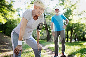 Beautiful senior couple running outside in forest