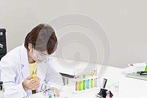 Beautiful senior female scientist mixing substances in test tube