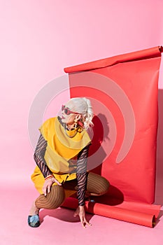 Beautiful senior model posing over red background