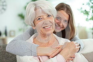 beautiful senior mom and adult daughter hugging