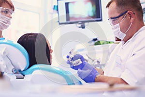 Beautiful senior woman at dentist having dental treatment at dentist's office