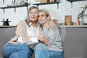 Beautiful senior woman and her adult daughter hugging and smiling