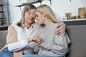 Beautiful senior woman and her adult daughter hugging and smiling