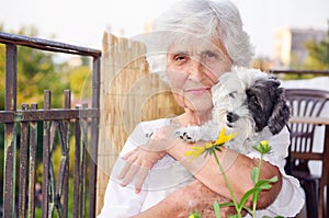 Beautiful senior woman hugging her dog