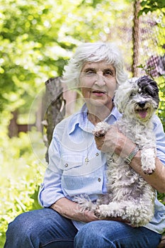 Beautiful senior woman hugging her dog