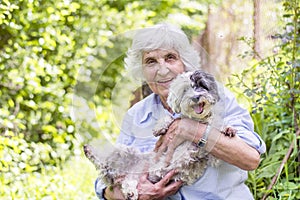 Beautiful senior woman hugging her dog