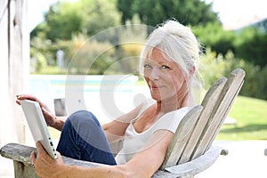 Beautiful senior woman reading book