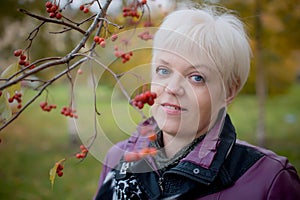 Beautiful senior woman relaxing in the fall park