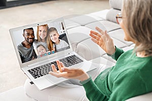 Beautiful senior woman using laptop for video call at home