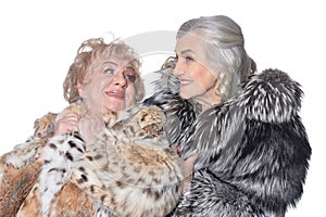 Beautiful senior women in fur coats isolated on white background