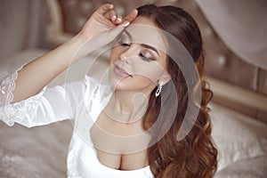 Beautiful sensual Bride wedding Portrait. Beauty makeup and elegant hairstyle. Brunette with curly hair style wearing in white se