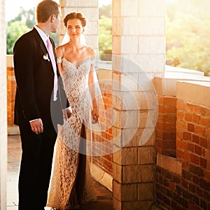 Beautiful sensual brunette bride and handsome groom at sunset ca