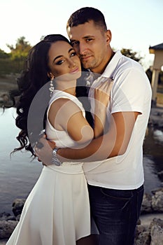 Beautiful sensual couple in elegant clothes posing in summer park