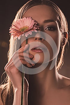 beautiful sensual girl holding gerbera flower,
