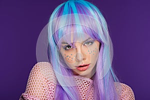 Beautiful sensual girl posing in violet wig with stars on face, isolated