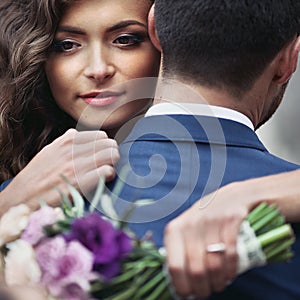 Beautiful sensual newlywed bride hugging handsome groom face