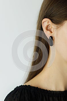 Beautiful sensual woman with modern black geometric earring, close up view. Space for text. Beauty