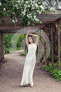 Beautiful sensual woman in white dress in flowers garden outdoors