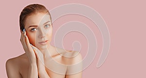 Beautiful sensual young girl with clean skin on a pink background with a mockup. Topless woman. The concept of spa treatments,