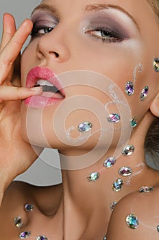 Beautiful sensual young woman with stones on face