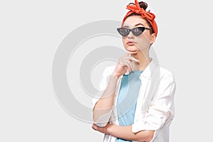 Beautiful serious brunette young woman wears black sunglasses, white shirt and trendy red headband