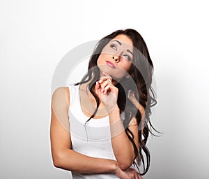 Beautiful serious young smiling woman with finger under the face