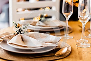 Beautiful served table with gold table top, plates , napkins and glasses. Holiday setting, Christmas mood