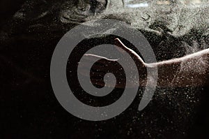 Beautiful set of dust particles and a hand against the background of rays of light in a dark room